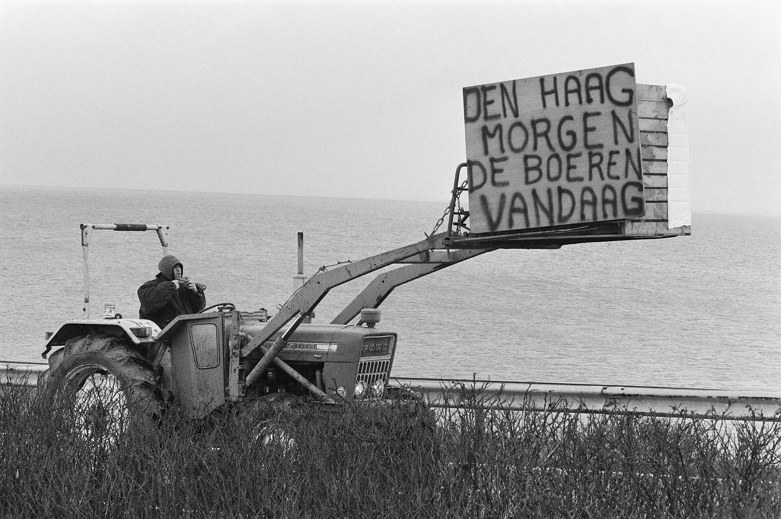 Een tractor met een protestbord tijdens een boerenprotest