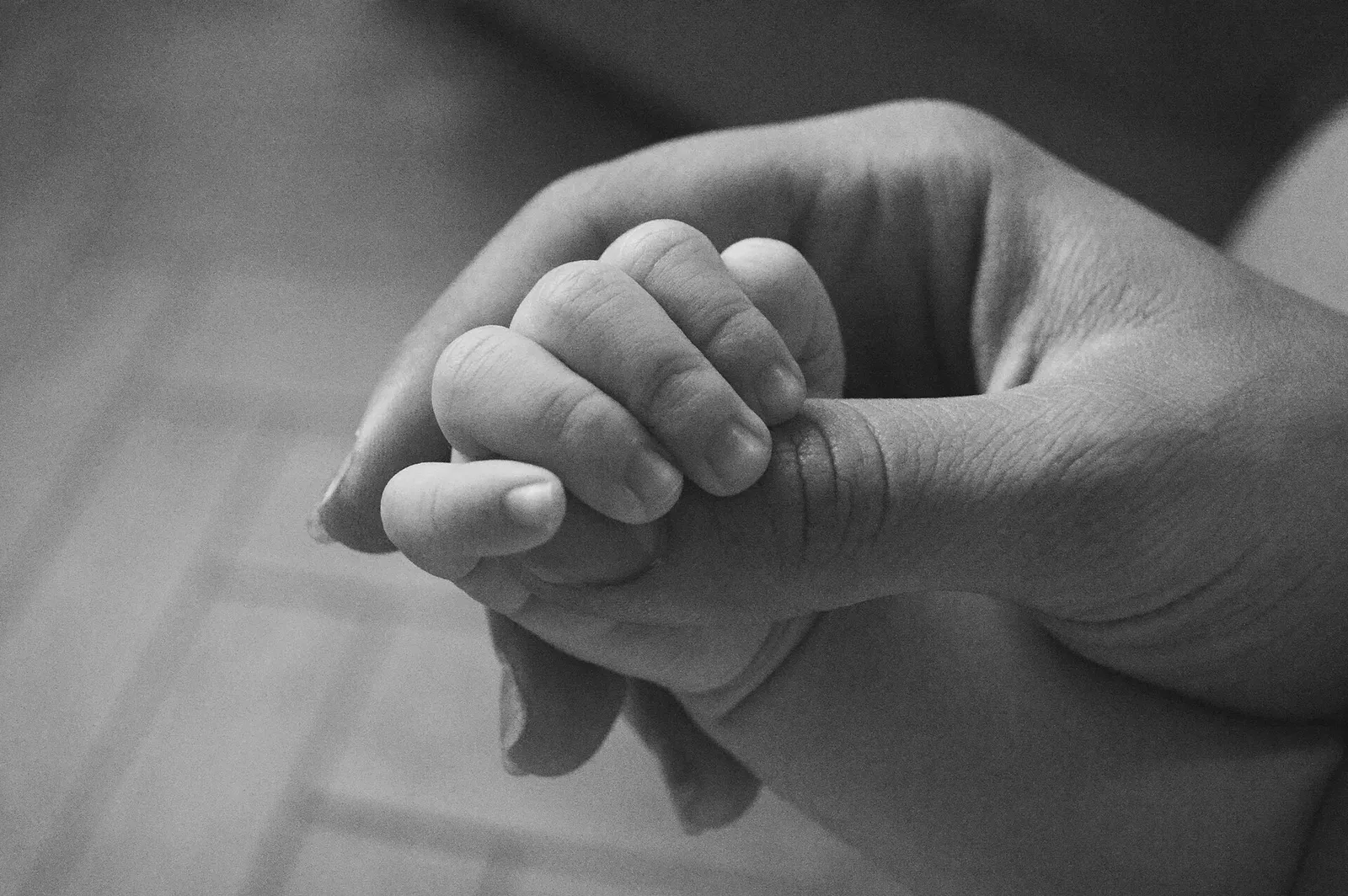 Een babyhandje dat een volwassen vinger vasthoudt (archiefbeeld, ter illustratie)