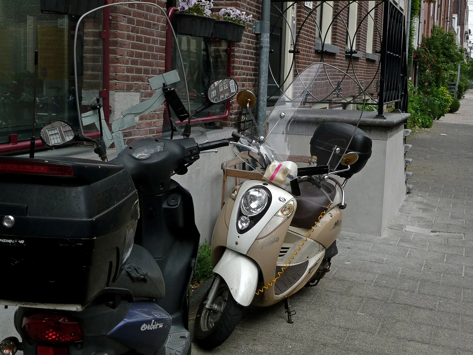 Geparkeerde scooters in een Amsterdamse straat (archiefbeeld)