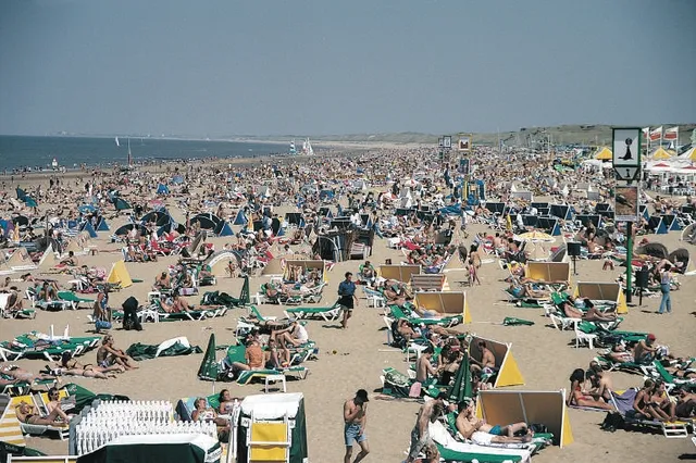 Een druk Nederlands strand op een zomerse dag