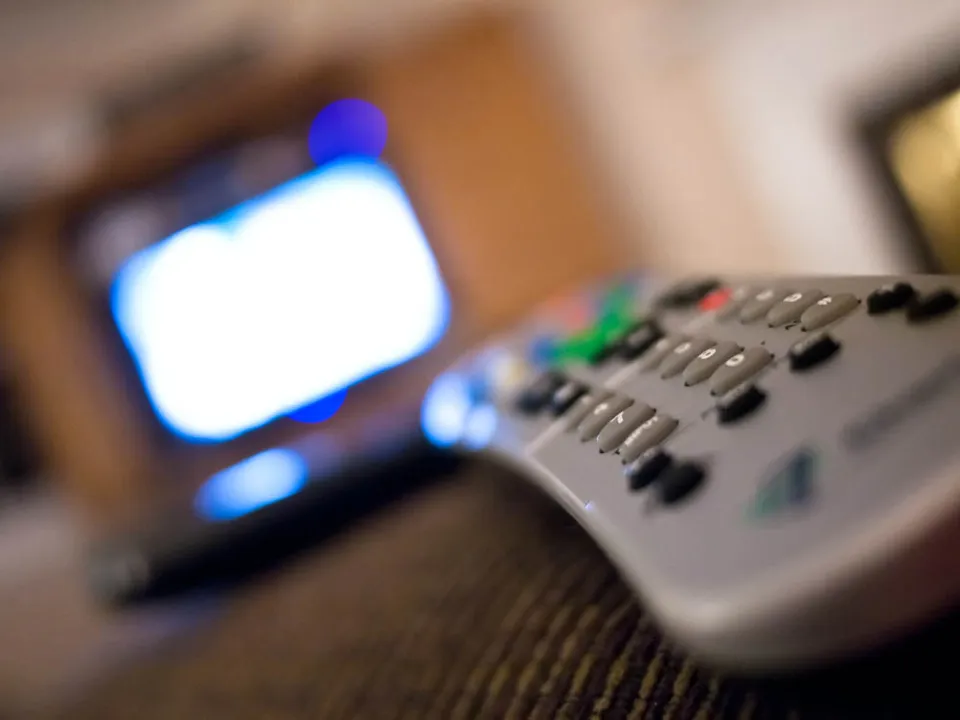 Een hand met een tv-afstandsbediening (archiefbeeld, ter illustratie)