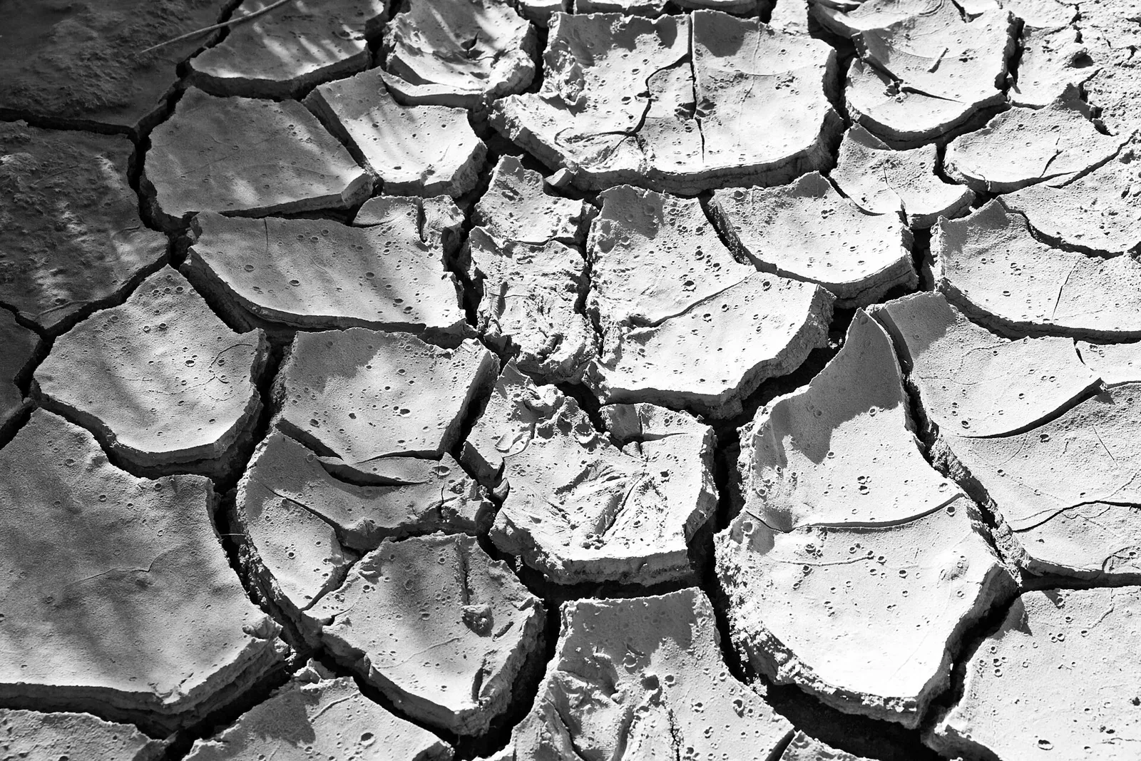 Uitgedroogde, gebarsten bodem tijdens een droge periode