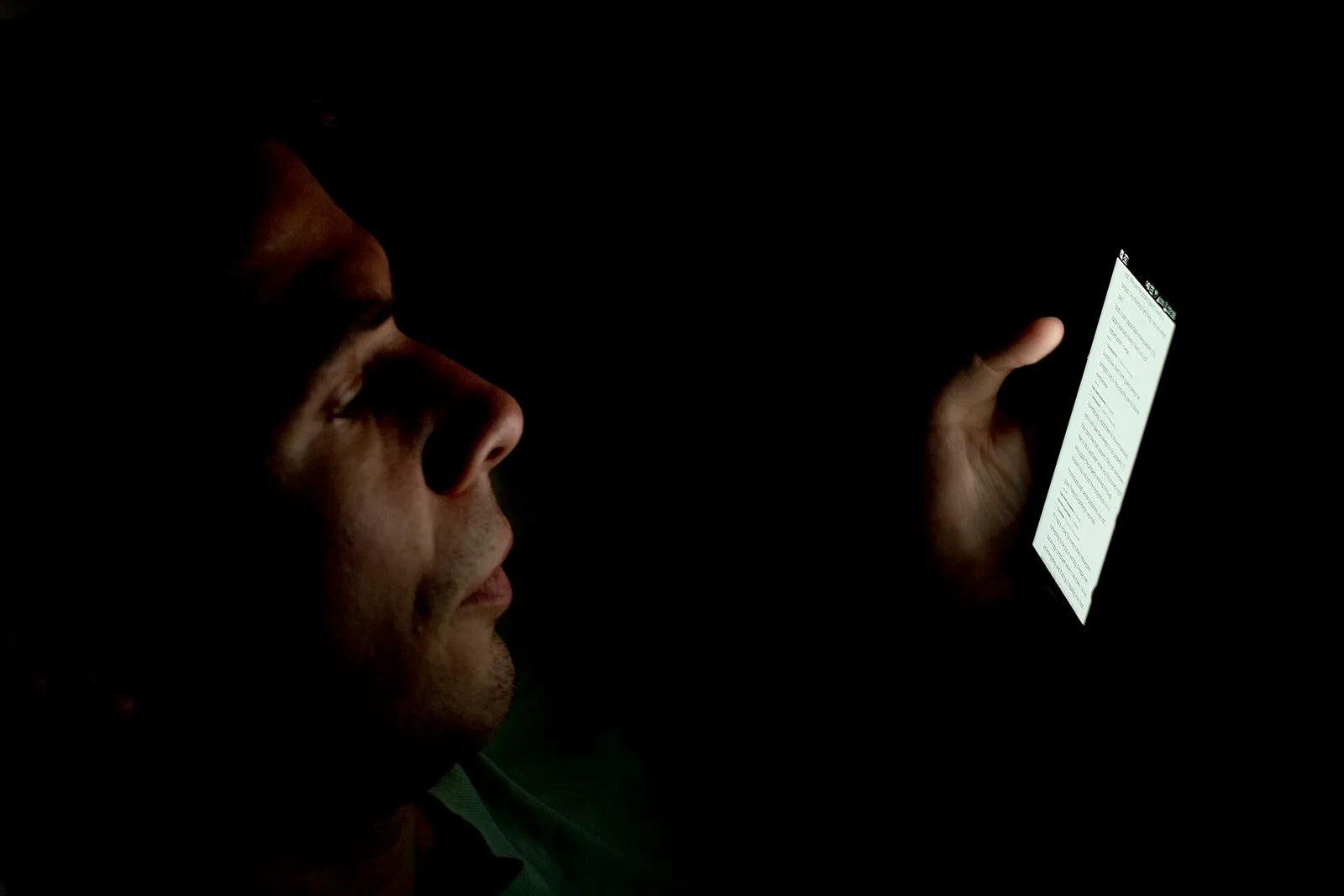 Iemand kijkt in het donker op een smartphone (ter illustratie)